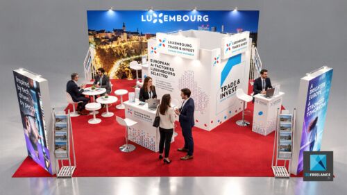 designer de stand d'exposition sur mesure avec moquette rouge, comptoirs d'accueil et signalétique pour salon professionnel